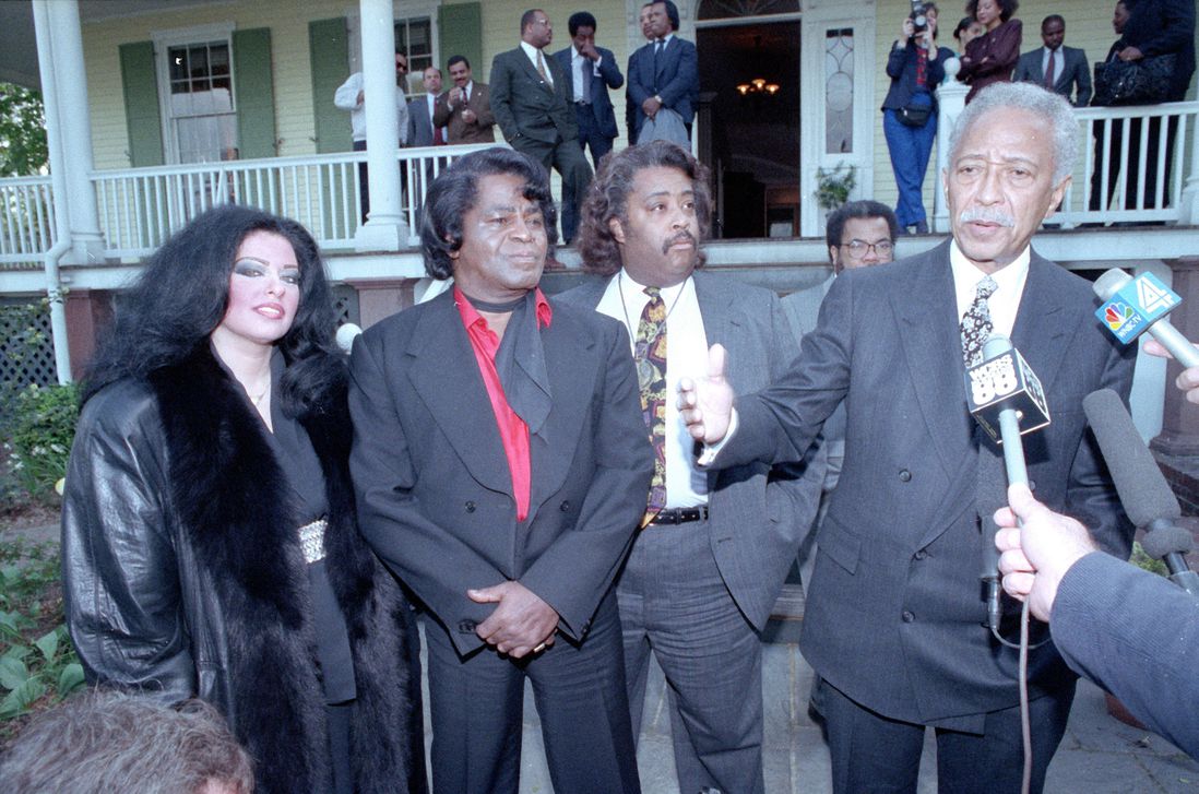 "Mayor David Dinkins speaks to reporters at Gracie Mansion with singer James Brown, his wife Adrienne, and the Rev. Al Sharpton. Brown congratulated the mayor on keeping New York relatively peaceful while Los Angeles erupted in protest against the Rodney King verdict."